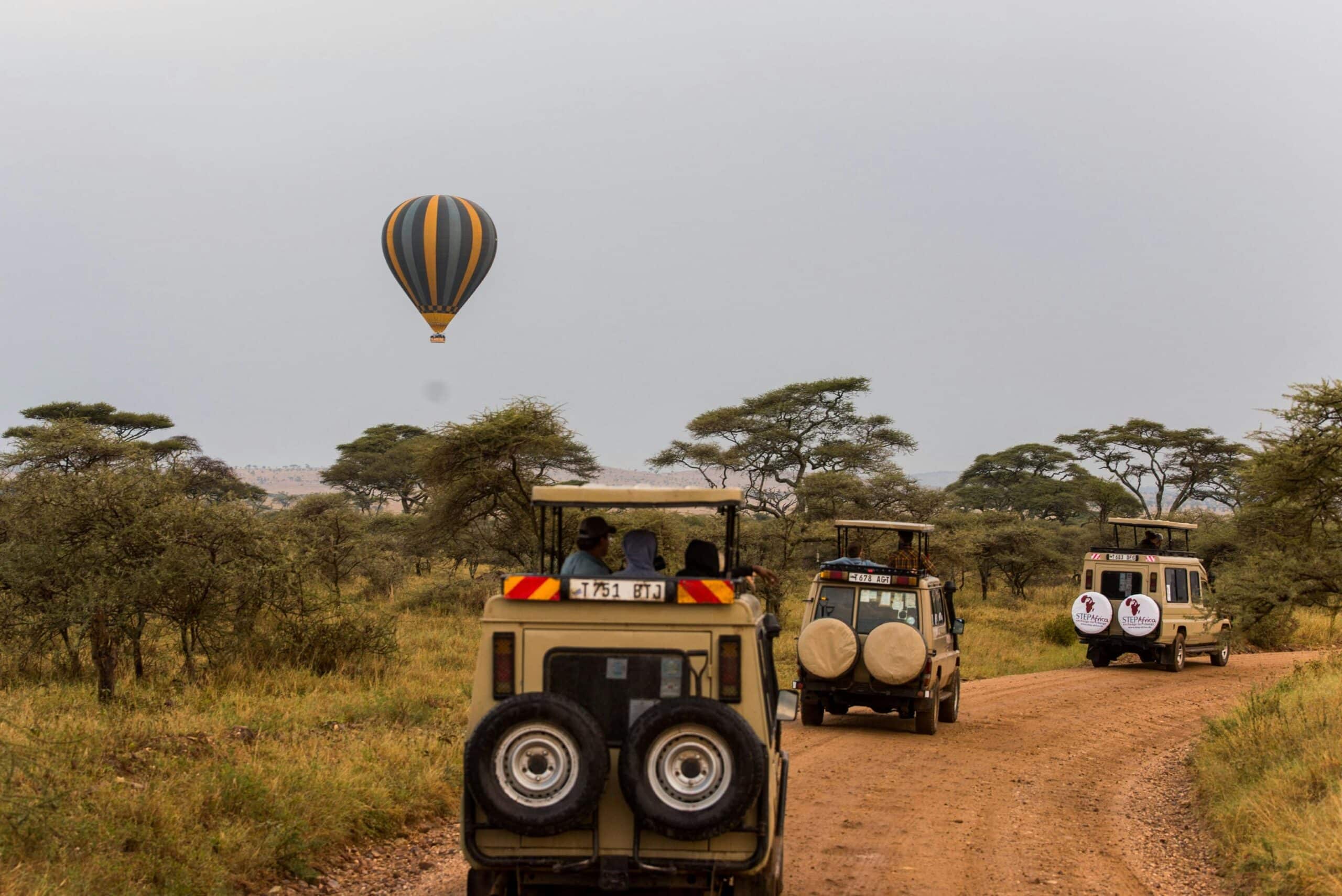 Scenic safari adventure in Tarangire with off-road vehicles and a hot air balloon in the savannah.